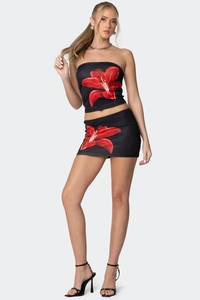 Detail von figurbetontem schwarzem Bandeau-Top und Minirock-Set mit rotem Blumendruck