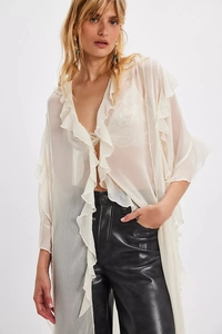 Detail showing the layered ruffles and sheer chiffon fabric of this cream blouse