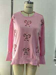 Detail of pink Christmas sweatshirt featuring festive sequined candy cane patterns