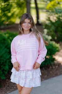 Détail du sweat-shirt rose avec motif drapeau américain en dentelle florale et patchwork