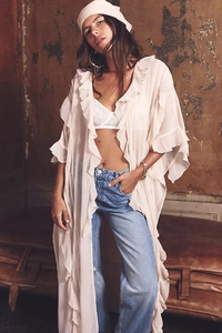 Detail of light pink chiffon cardigan with ruffled layers and bohemian vacation style