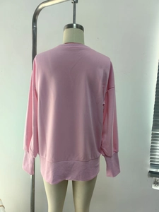 Detailed back view of pink crewneck sweatshirt featuring ribbed cuffs and drop shoulder design