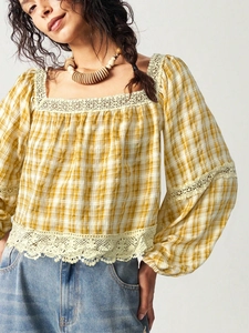 Detail of square neck yellow plaid blouse with delicate lace stitching and cotton texture