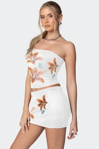 Detail von Blumen und Schmetterlingsdruck auf weißem trägerlosem Top und Minirock Set