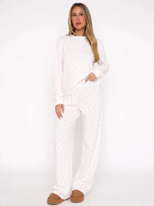 Women's pajama set featuring pink bow prints on white waffle knit fabric with long sleeves