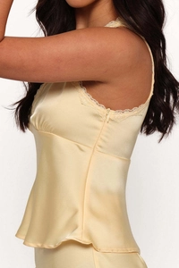 Detailed view of pale yellow satin dress featuring delicate lace trim and side zipper