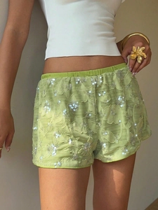 Close-up of fruit green sequin shorts featuring floral embroidery and elastic waist