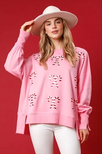 Detail of pink Christmas sweatshirt showing candy cane print and side slit hem design