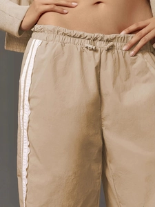 Beige high-waist wide-leg pants with side lace stripes and adjustable drawstring