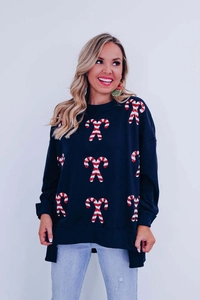 Detail of loose Christmas sweatshirt with candy cane sequins and side slits design
