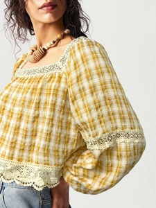 Detail of gingham plaid fabric with delicate lace crochet trim on a puff sleeve top