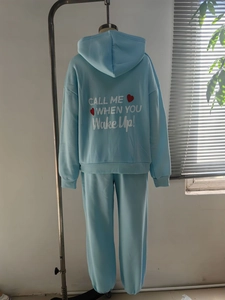 Detail of light blue tracksuit set showing back white text print and red heart design