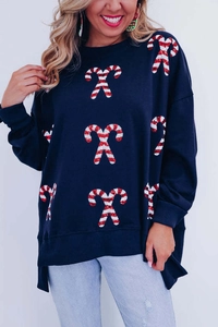 Detailed close-up of Christmas candy cane graphics on oversized navy sweatshirt