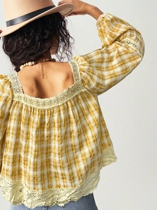 Detailed back view of a yellow plaid shirt with delicate lace trim and square neck design