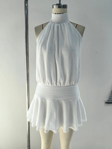 Detailed close-up of white knit halter neck dress showing intricate hollow-out texture