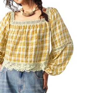 Detail of yellow plaid pattern with delicate lace patchwork and puff sleeve textures