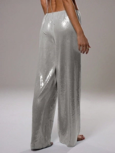 Détail macro du pantalon à paillettes argentées montrant la texture et l'éclat métallique