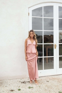 Detail view of pink satin halter dress with lace trim and elegant backless design