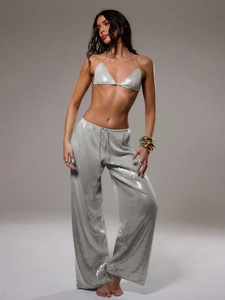Détail du pantalon large à paillettes argentées montrant le tissu métallique brillant