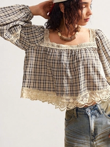 Close-up of bohemian plaid blouse featuring intricate lace trim on the square neckline