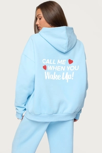 Detail of light blue oversized hoodie back with white graphic print and red heart design