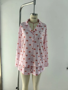 Close-up of pink long sleeve pajama set with red lip prints and button details