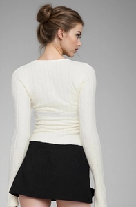 Detail of white long sleeve top showing ribbed texture and lace patchwork on the back