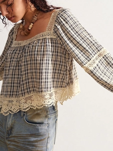 Close-up of bohemian plaid shirt with vintage square neck and delicate lace trim detail