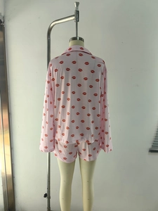 Detailed view of pink long-sleeve pajama top and shorts with red lip prints