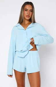 Detail of light blue long sleeve button-up pajama shirt and matching shorts set