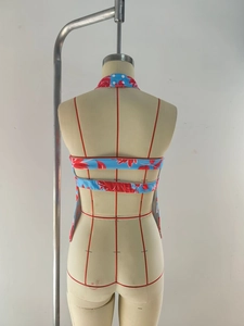 Detail of floral halter top featuring backless design with two parallel strappy ties