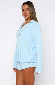 Detail of light blue long-sleeve pajama set with buttons and chest pocket in soft cotton