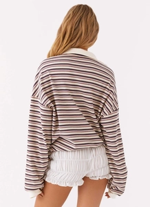 Dettaglio posteriore di una maglia a righe retrò con colletto polo vintage e maniche lunghe