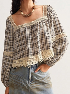 Detail of checkered blouse featuring delicate white lace patchwork and ruffled sleeves