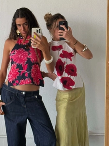 Detail of two summer halter tops with navy floral and red poppy prints on slim fit design