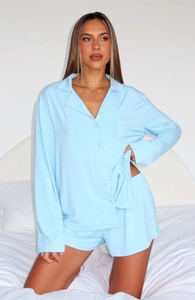 Close-up of light blue long-sleeved buttoned pajama top with soft fabric texture and pocket