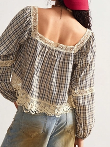 Detail of crochet lace patchwork and plaid pattern on a vintage puff sleeve blouse