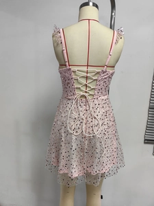 Detail van de roze lovertjesjurk met vetersluiting aan de achterkant en mesh-zoom