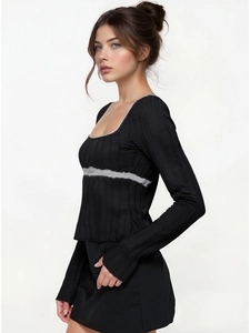 Detailed texture of black long sleeve knit top with grey fuzzy trim and ribbed fabric