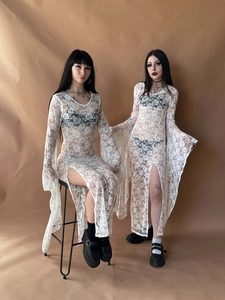 Detail view of white lace dress with floral crochet pattern and high side slit