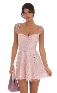 Detail van roze paillettenjurk met hartvormige halslijn en gerimpelde mesh bandjes