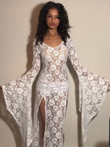 Detail of white rose lace fabric with sheer texture and flared sleeves on a slim dress