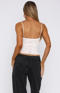 Vue arrière d'un caraco blanc à col en V avec un jean en denim noir classique