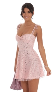 Detail van roze mini-jurk met pailletten, hartvormige halslijn en ruches bandjes