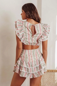 Detail of back tie-up ruffled top and layered floral skirt with pom-pom trim