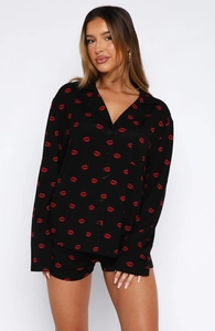 Detail view of black pajama set with red lip print, long-sleeve shirt and matching shorts