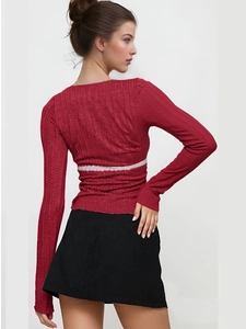 Detail of red long sleeve slim-fit knit top with white lace patchwork and ribbed texture