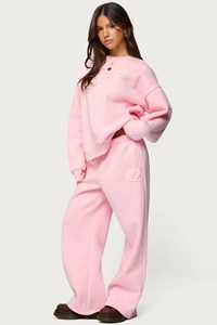 Detail of pink lounge set showing soft fleece fabric and lace heart patch accents