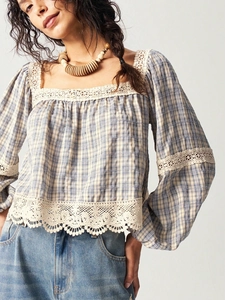 Detail shot of the blue and white checkered fabric with delicate white lace inserts