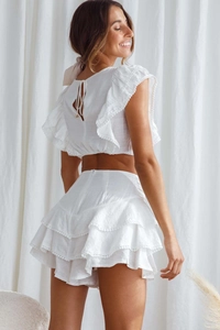 Detail of white two-piece set with ruffle short top and tiered skirt for summer